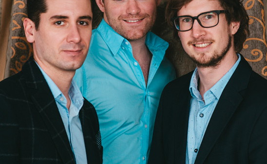 Foto: Drei junge Männer stehen nebeneinander und schauen in die Kamera.